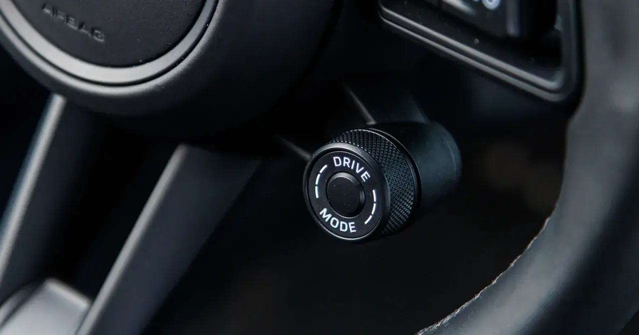 Pokrętło wyboru trybu jazdy w samochodzie, z opcją "DRIVE MODE", gotowe do aktywacji trybu sport.