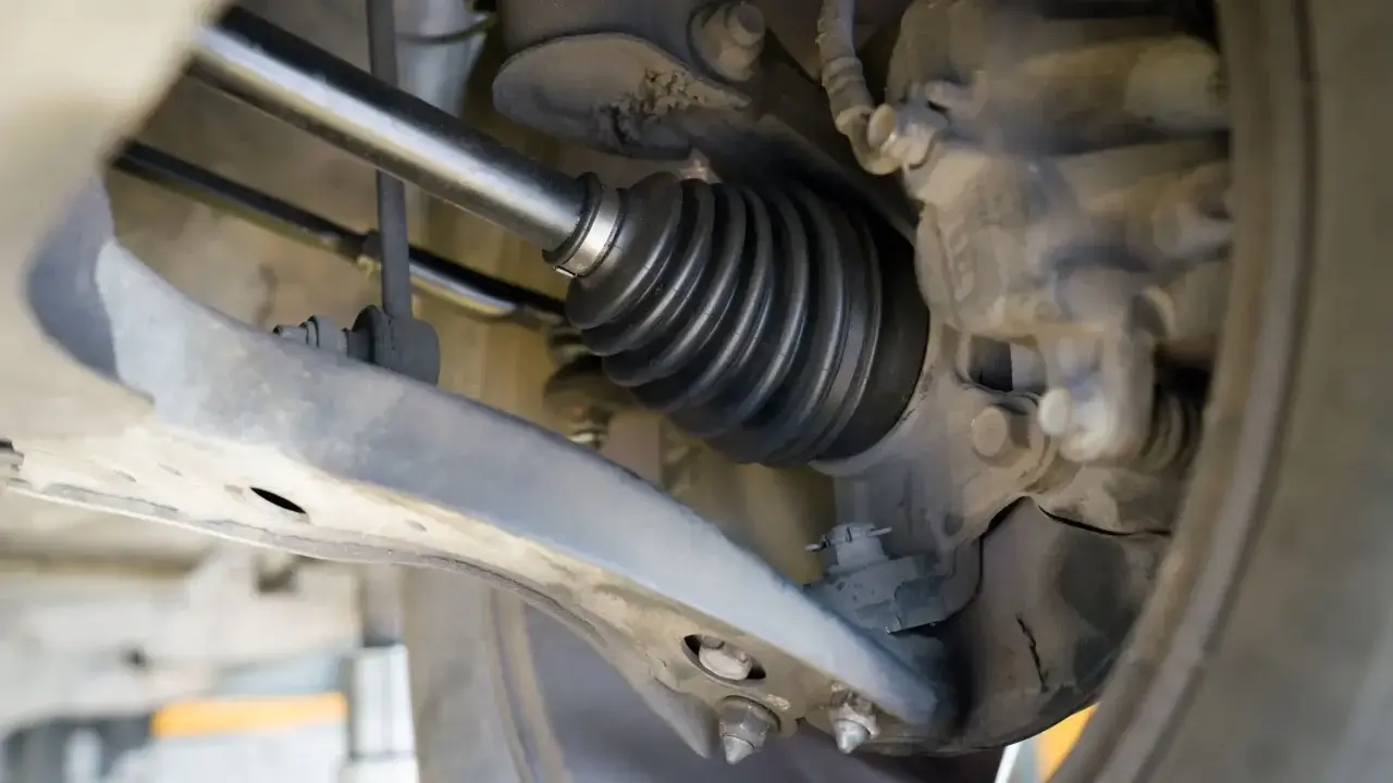 Szczegółowy widok mechanizmu napędowego, pokazujący osłonę przegubu. To kluczowy etap w instrukcji wymiany półosi krok po kroku.