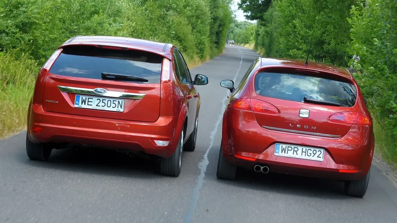 Dwa czerwone auta jadące obok siebie. Ford Focus i Seat Leon. Wymijanie a omijanie na wąskiej drodze.