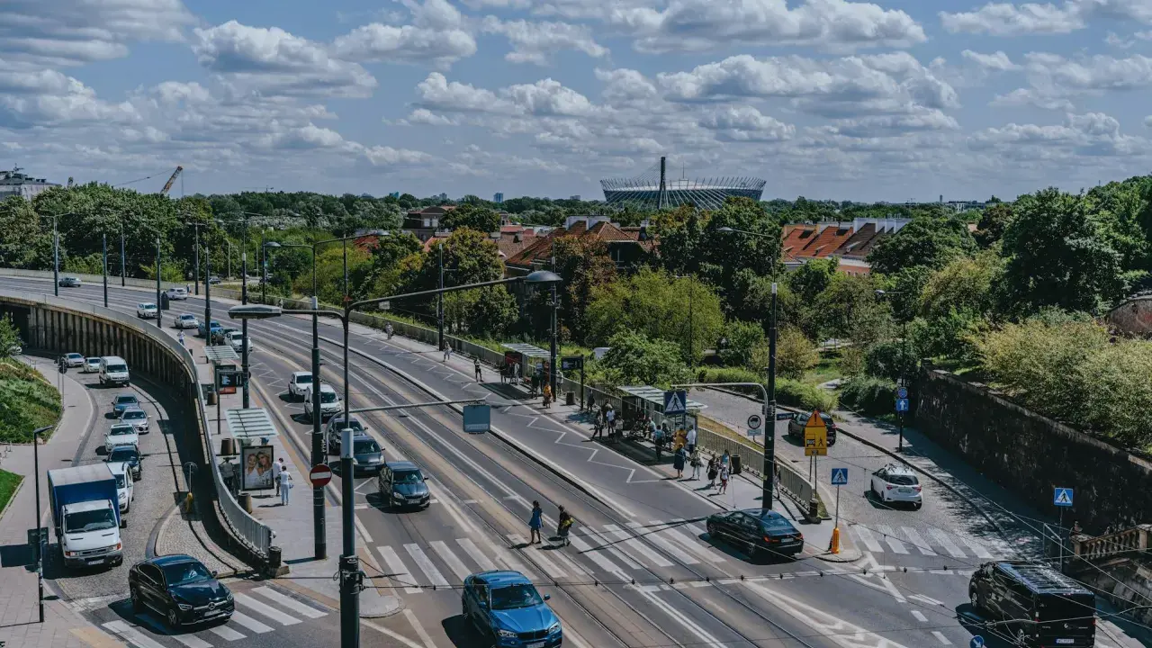 Na skrzyżowaniu z tramwajami, samochody zatrzymują się przed linią warunkowego zatrzymania, czekając na zielone światło.