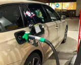 Tankowanie samochodu, zielony pistolet paliwa wlewa się do baku. Obawy o złej jakości paliwo diesel objawy mogą pojawić się po takiej wizycie na stacji.