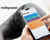 Dłoń wybiera "mPrawo jazdy" na ekranie aplikacji mObywatel, gdzie można zarządzać cyfrowym kontem kierowcy i innymi dokumentami.