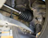 Szczegółowy widok mechanizmu napędowego, pokazujący osłonę przegubu. To kluczowy etap w instrukcji wymiany półosi krok po kroku.