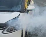 Biały samochód z otwartą maską, z której wydobywa się gęsty dym. Awaria silnika?