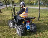 Chcesz wiedzieć, jakie prawo jazdy na quada? Kierowca w kamizelce odblaskowej i kasku siedzi na quadzie, gotowy do jazdy.