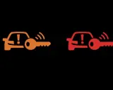 Pomarańczowa i czerwona kontrolka auto z kluczem, sygnalizujące problem z immobilizerem lub kluczykiem.