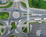 Widok z lotu ptaka na rondo i skrzyżowanie. Samochody i autobusy poruszają się po drogach. Zjazd z ronda na który pas?