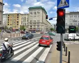 Zielona strzałka w prawo na sygnalizatorze świetlnym wskazuje kierunek jazdy. Ruch uliczny na skrzyżowaniu w słoneczny dzień.