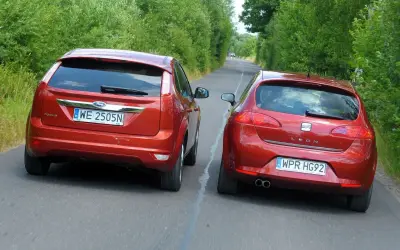 Dwa czerwone auta jadące obok siebie. Ford Focus i Seat Leon. Wymijanie a omijanie na wąskiej drodze.