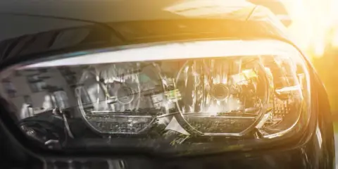 Reflektor samochodu w słońcu. Uważaj, by nie dostać mandatu za brak świateł!