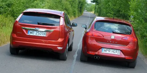 Dwa czerwone auta jadące obok siebie. Ford Focus i Seat Leon. Wymijanie a omijanie na wąskiej drodze.