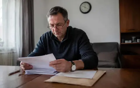 Mężczyzna w okularach analizuje dokumenty, martwiąc się o przedawnienie wykroczenia.