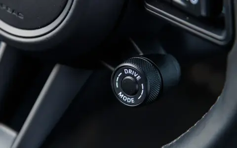 Pokrętło wyboru trybu jazdy w samochodzie, z opcją "DRIVE MODE", gotowe do aktywacji trybu sport.