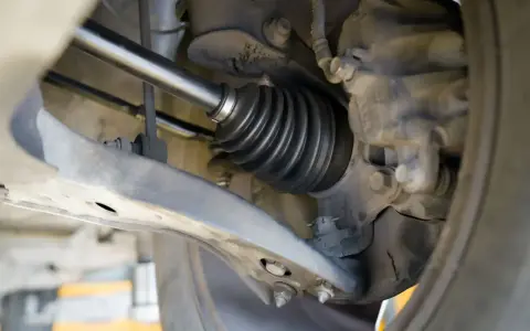 Szczegółowy widok mechanizmu napędowego, pokazujący osłonę przegubu. To kluczowy etap w instrukcji wymiany półosi krok po kroku.