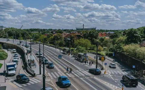 Na skrzyżowaniu z tramwajami, samochody zatrzymują się przed linią warunkowego zatrzymania, czekając na zielone światło.