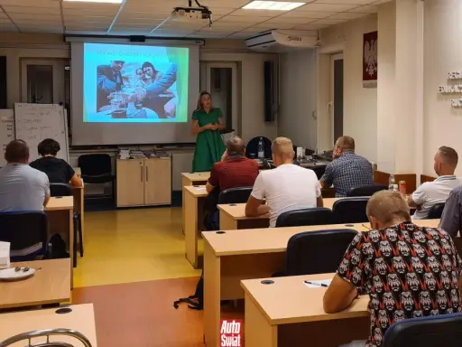 Szkolenie z zbijania punktów karnych. Wykładowczyni omawia rozwój choroby alkoholowej, a uczestnicy słuchają.