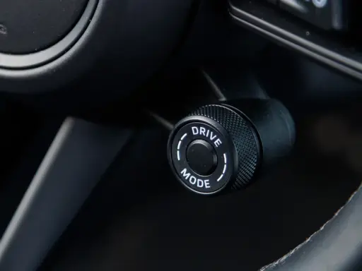 Pokrętło wyboru trybu jazdy w samochodzie, z opcją "DRIVE MODE", gotowe do aktywacji trybu sport.