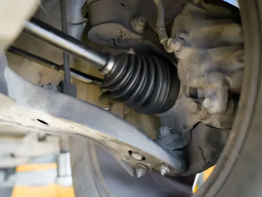 Szczegółowy widok mechanizmu napędowego, pokazujący osłonę przegubu. To kluczowy etap w instrukcji wymiany półosi krok po kroku.