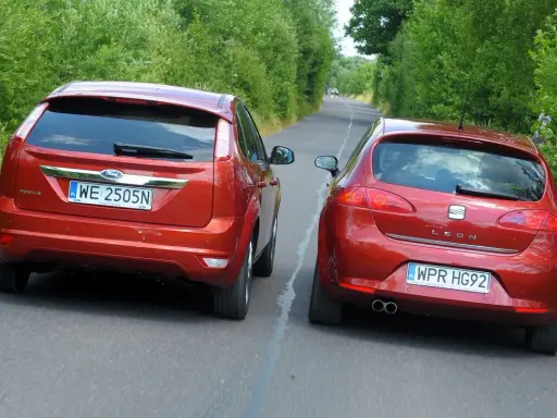 Dwa czerwone auta jadące obok siebie. Ford Focus i Seat Leon. Wymijanie a omijanie na wąskiej drodze.
