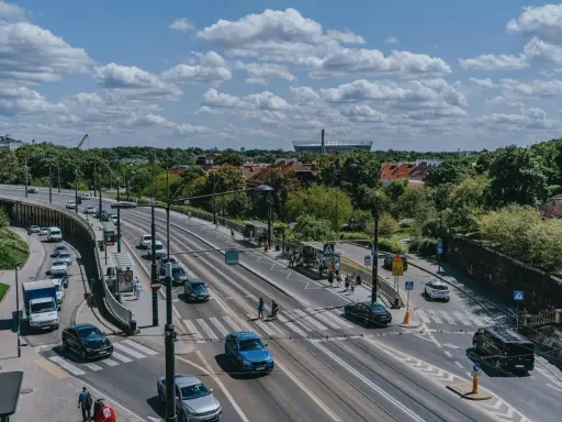 Na skrzyżowaniu z tramwajami, samochody zatrzymują się przed linią warunkowego zatrzymania, czekając na zielone światło.