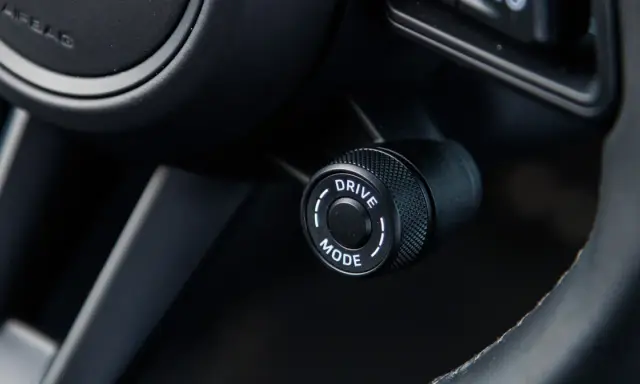 Pokrętło wyboru trybu jazdy w samochodzie, z opcją "DRIVE MODE", gotowe do aktywacji trybu sport.