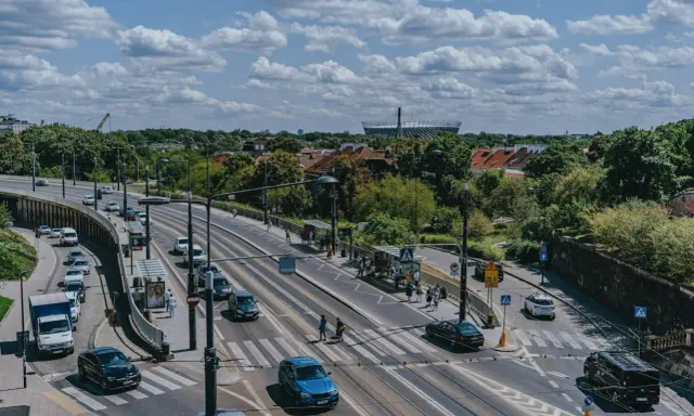 Na skrzyżowaniu z tramwajami, samochody zatrzymują się przed linią warunkowego zatrzymania, czekając na zielone światło.