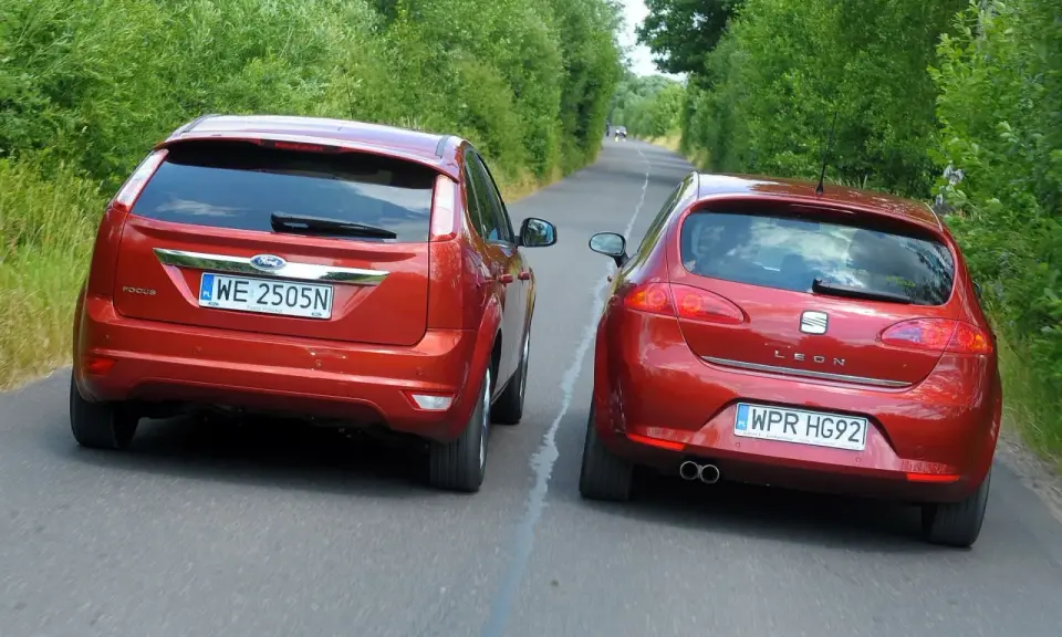 Dwa czerwone auta jadące obok siebie. Ford Focus i Seat Leon. Wymijanie a omijanie na wąskiej drodze.
