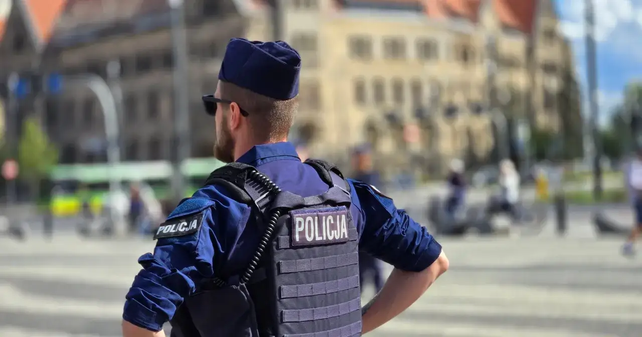 Policjant w kamizelce taktycznej z napisem