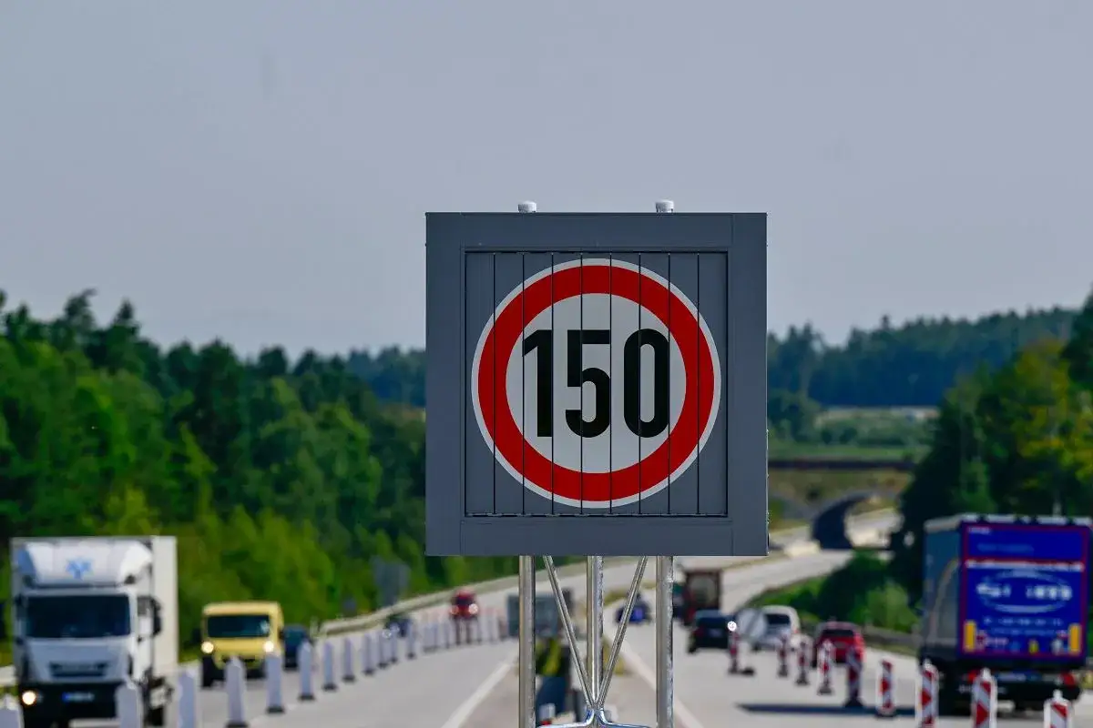 Znak ograniczenia prędkości 150 km/h na autostradzie w Czechach. Ruch samochodowy i ciężarowy na drodze.