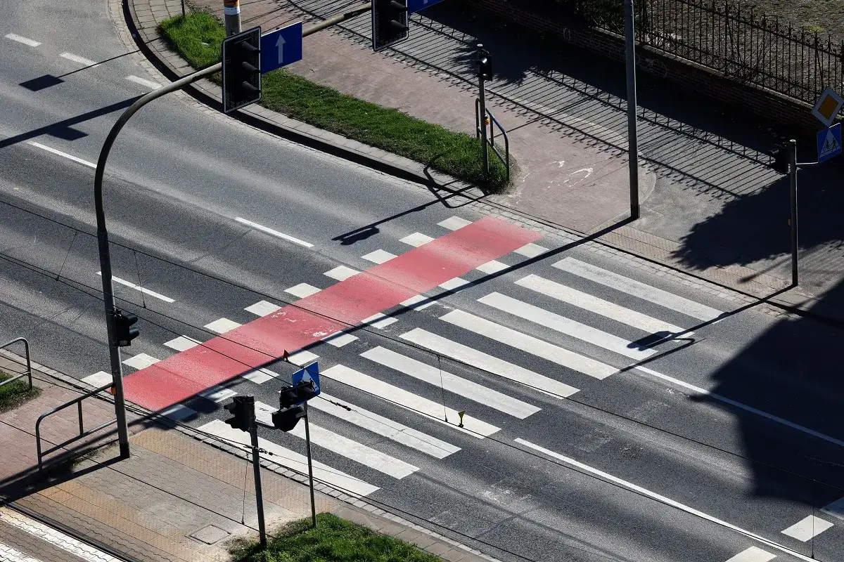 Przejście dla pieszych z czerwonym pasem, sygnalizacja świetlna. Kiedy należy zachować szczeg&oacute;lną ostrożność? Gdy światło jest zielone dla pojazd&oacute;w, a piesi czekają.