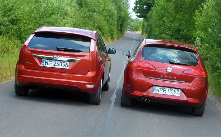 Dwa czerwone auta jadące obok siebie. Ford Focus i Seat Leon. Wymijanie a omijanie na wąskiej drodze.